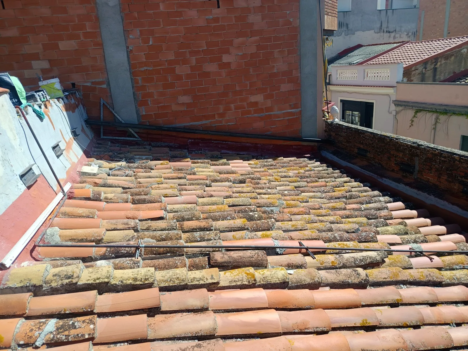 Tejado de teja árabe con musgo y piezas movidas, antes de la obra