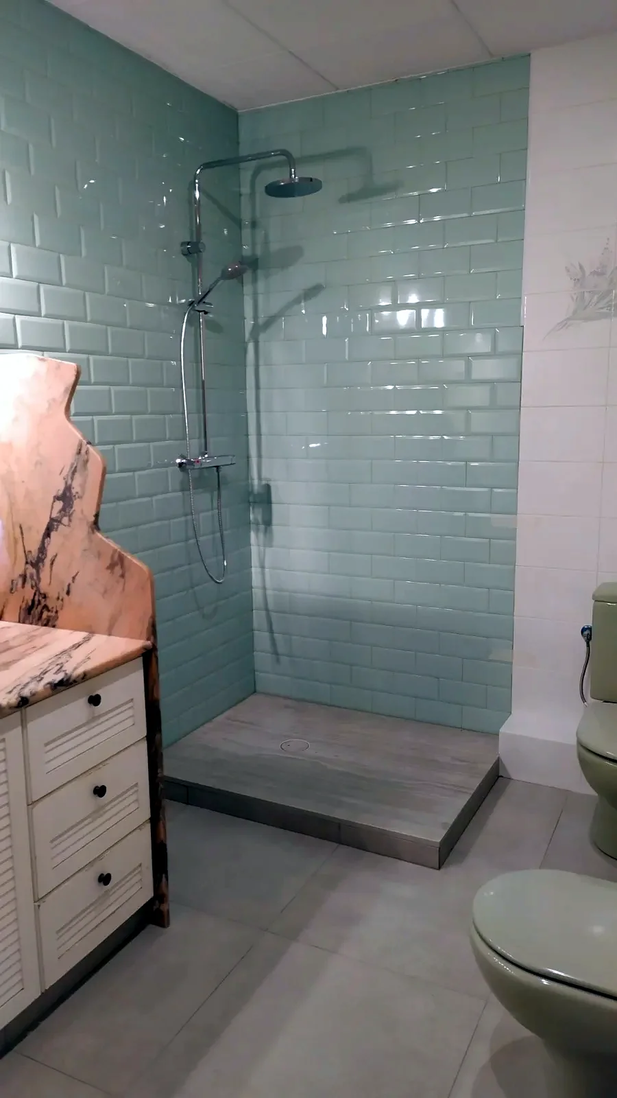 Ducha con plato y azulejo tipo metro en lugar de la antigua bañera
