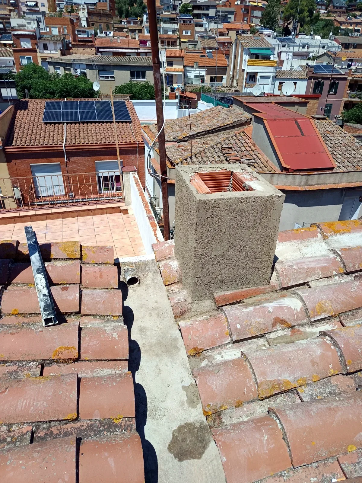 Tejado de teja con chimenea y encuentros sellados