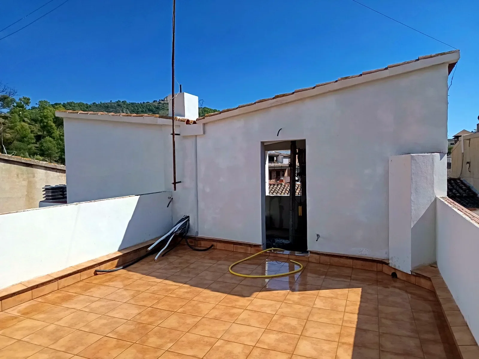 Terraza y caseta rehabilitadas, paredes blancas y suelo nuevo