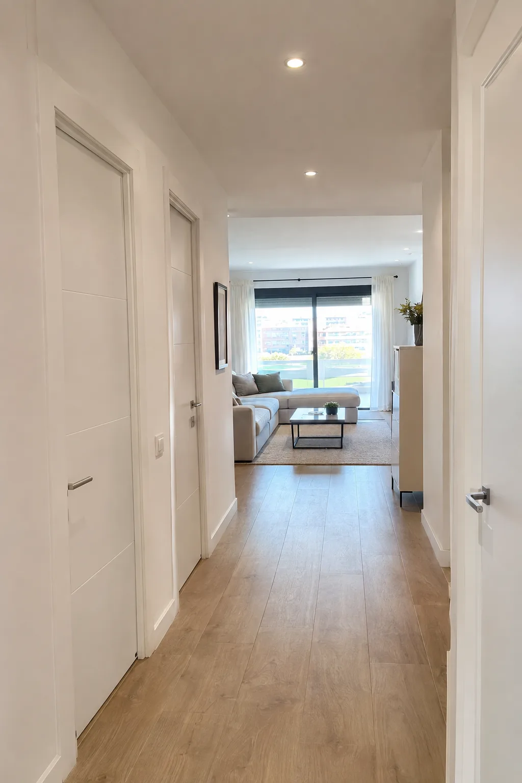 Pasillo y salón de un piso reformado con puertas blancas